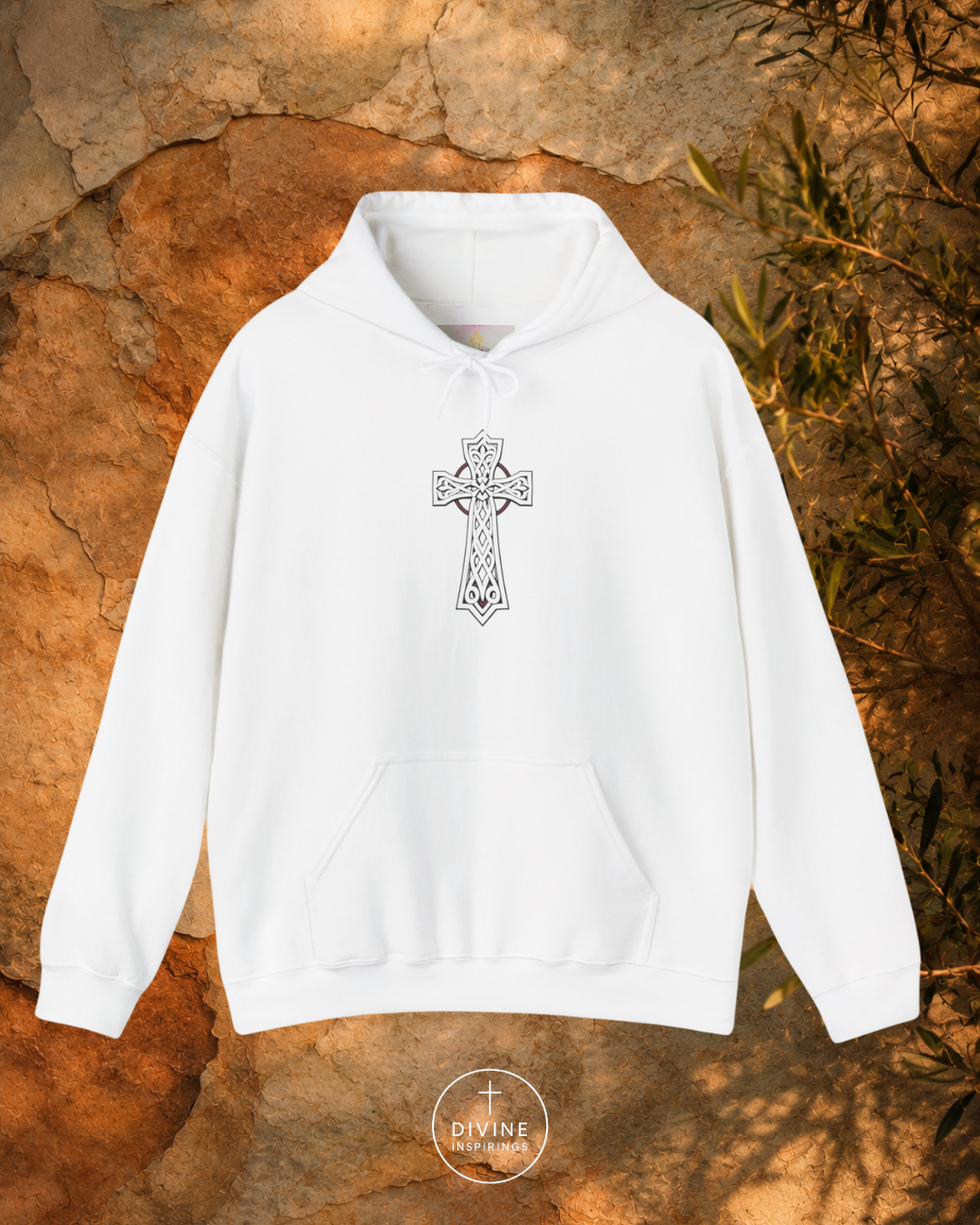 White hoodie with a Celtic cross design on a stone surface
