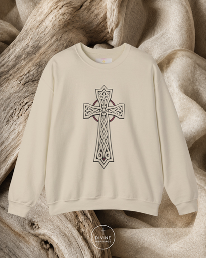 Beige sweatshirt with a Celtic cross design on a wooden surface, featuring the brand 'Divine Emporium'.
