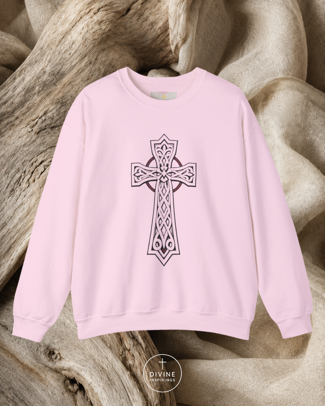 Pink sweatshirt with a black cross design on a textured beige background