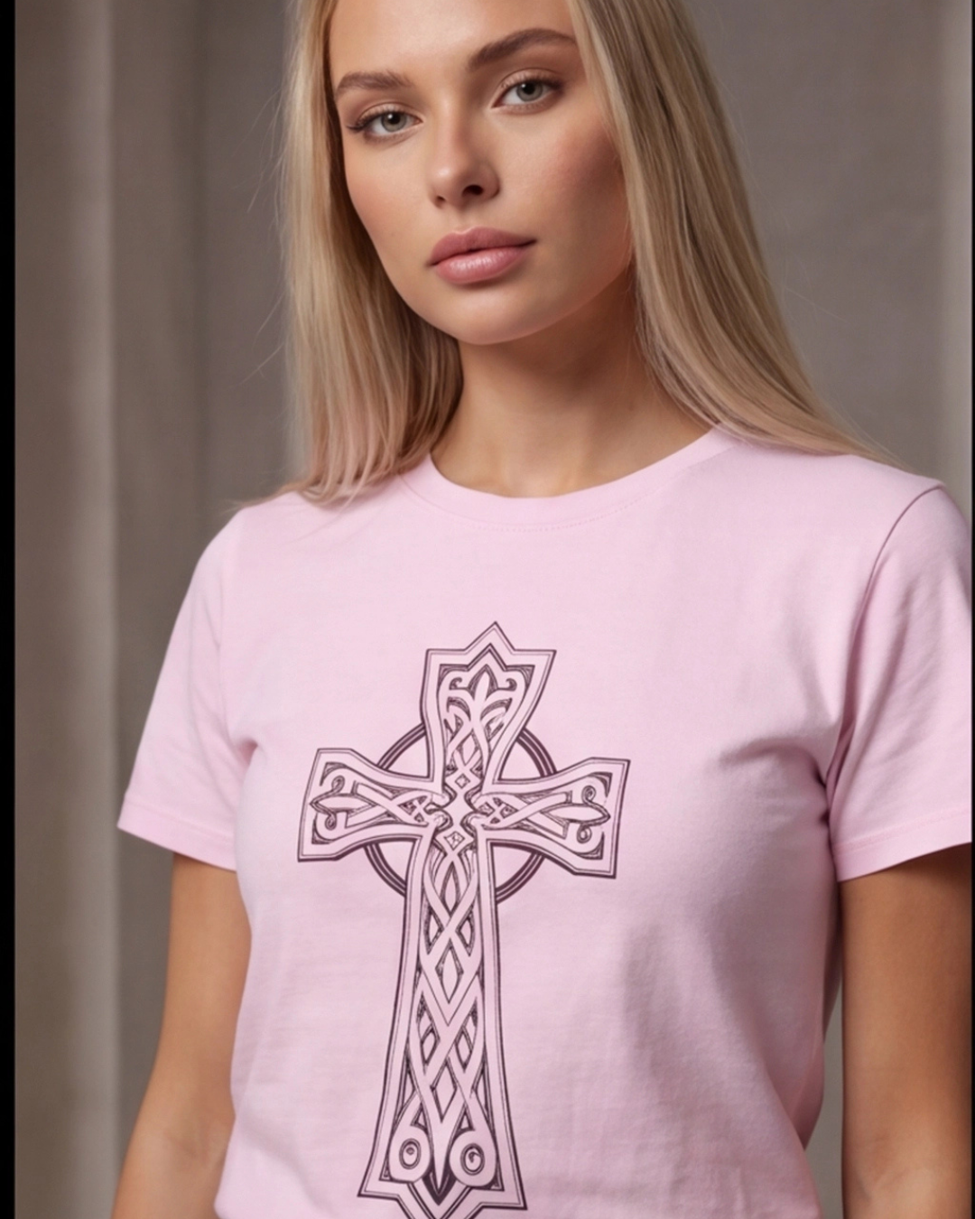Woman wearing a pink t-shirt with a Celtic cross design against a neutral background