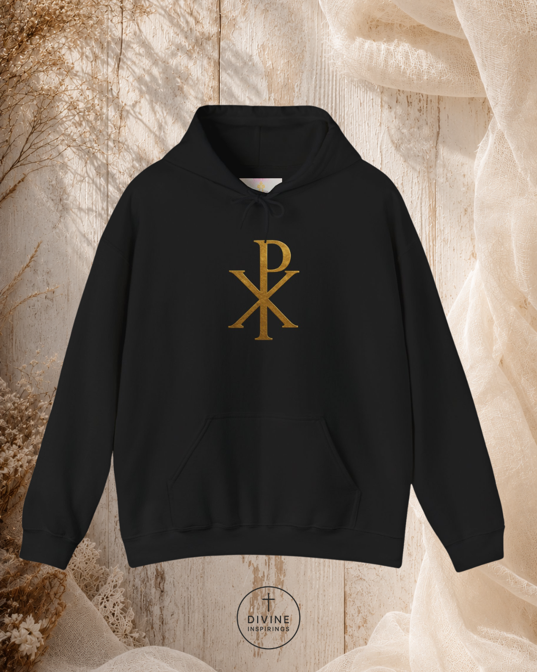 Black hoodie with gold symbol on a textured beige background