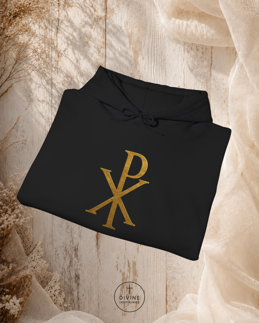 Black hoodie with gold logo on a textured beige background