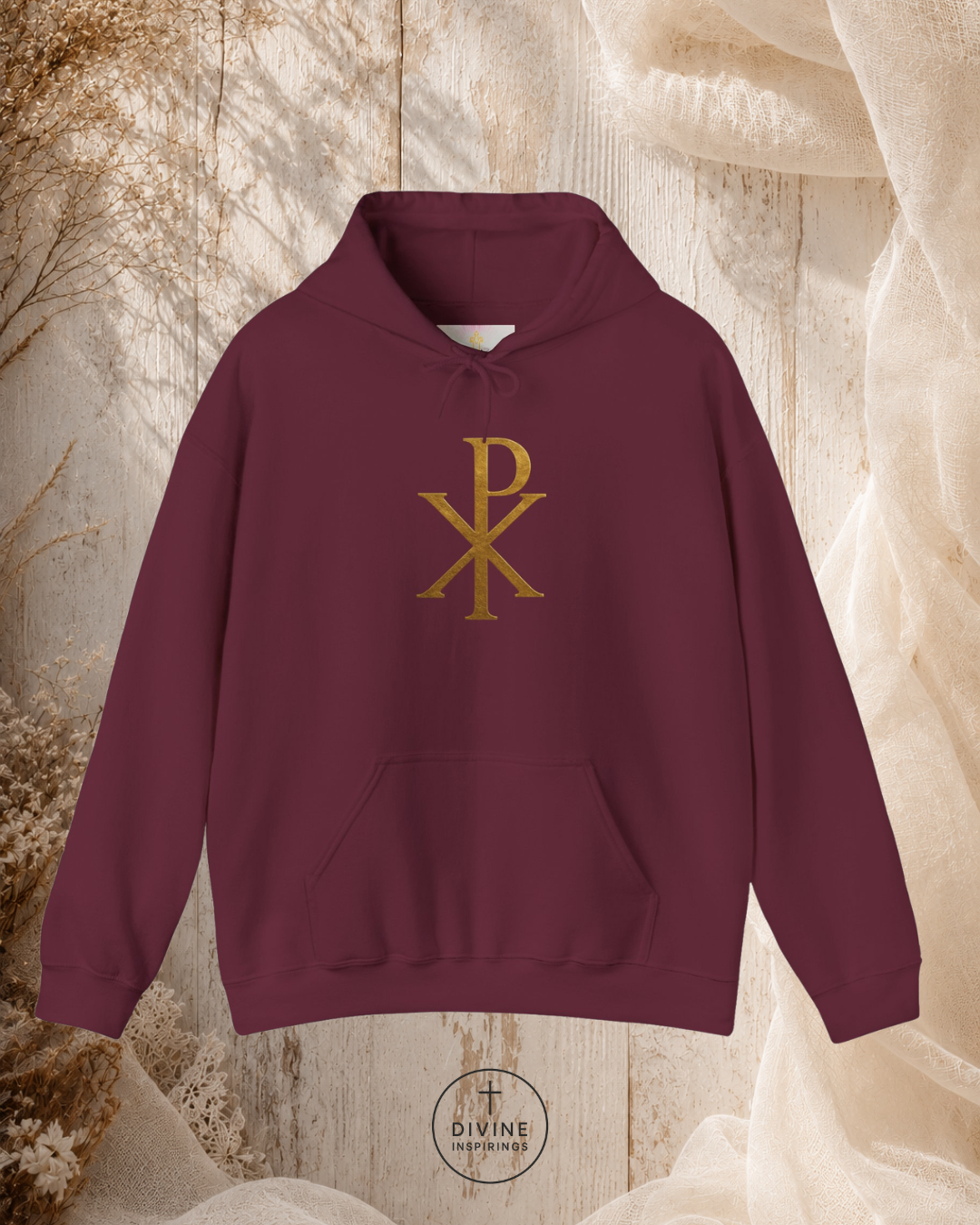 Maroon hoodie with gold symbol on a textured beige background