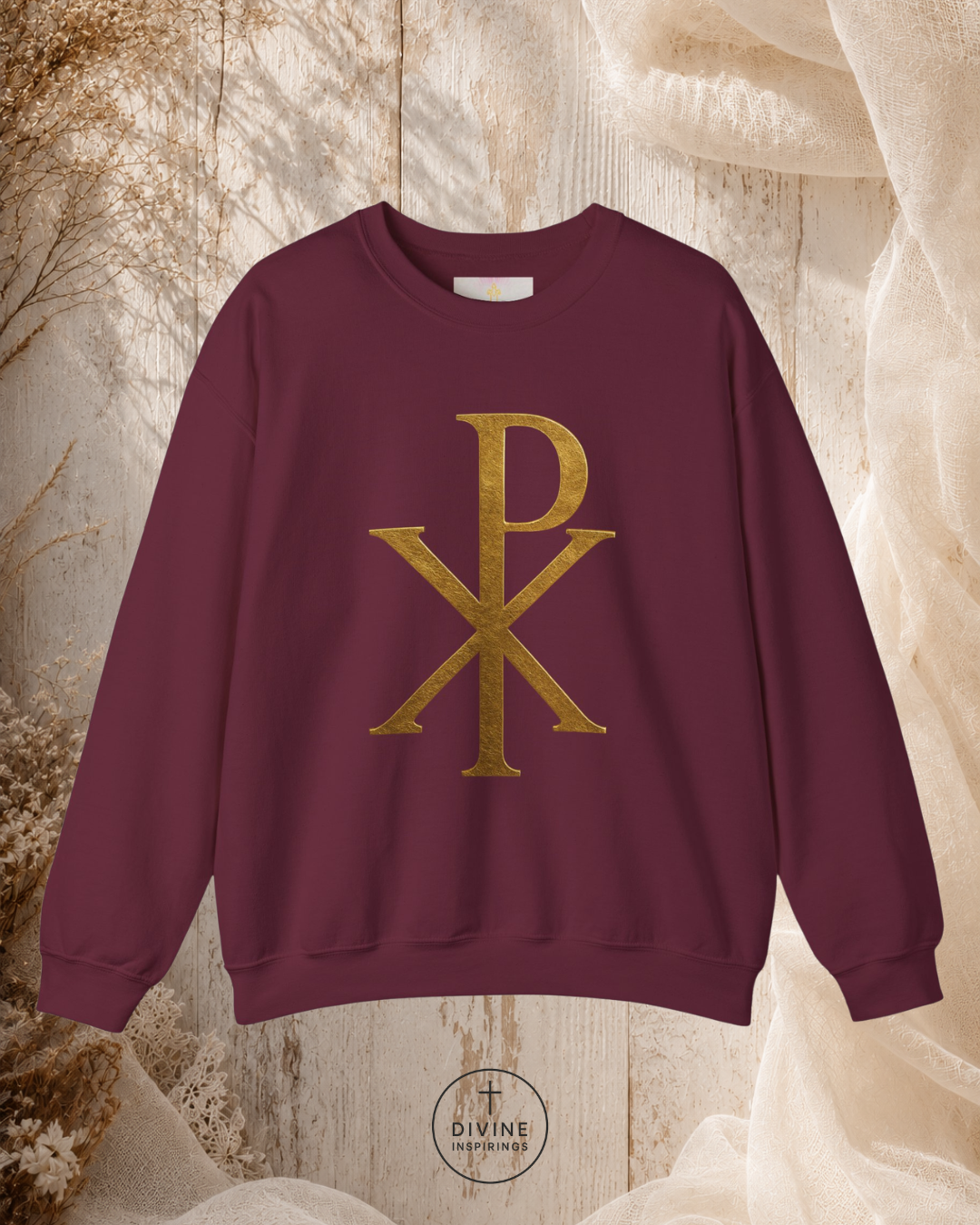 Maroon sweatshirt with gold symbol on a textured beige background