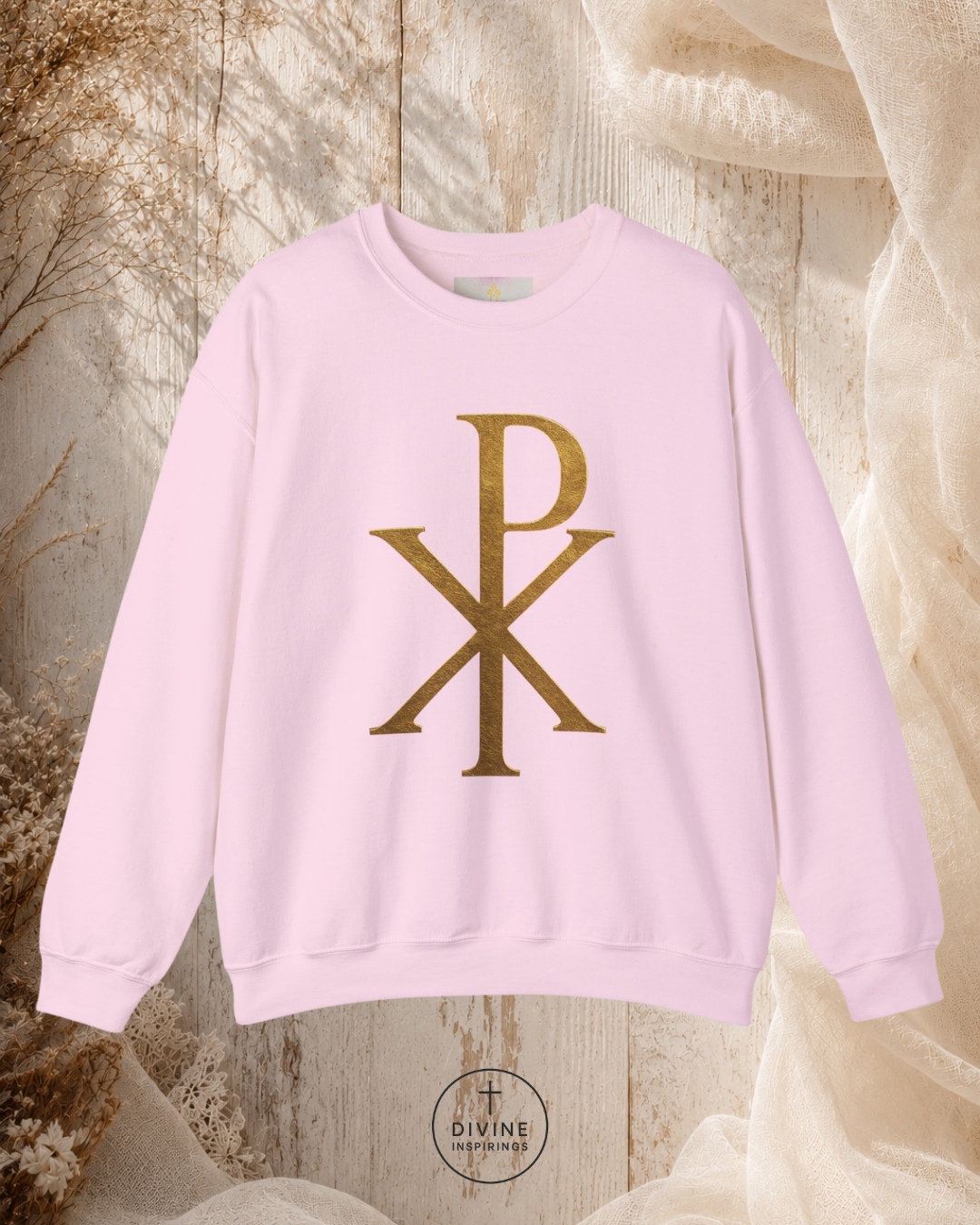 Pink sweatshirt with gold logo on a textured beige background