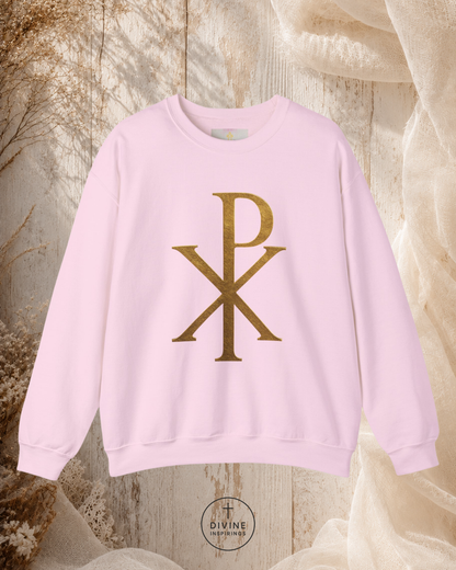 Pink sweatshirt with gold logo on a textured beige background