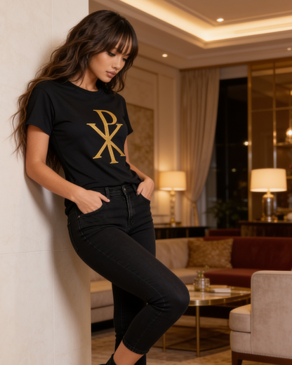 Woman wearing a black t-shirt with a gold logo in a living room setting