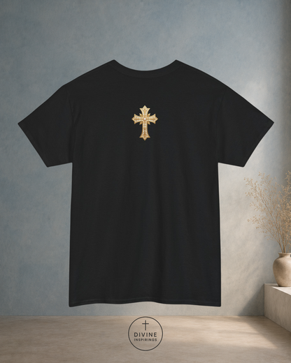 Black t-shirt with a gold cross on the back against a gray wall.