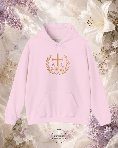 Pink hoodie with a gold cross and laurel wreath design on a floral background
