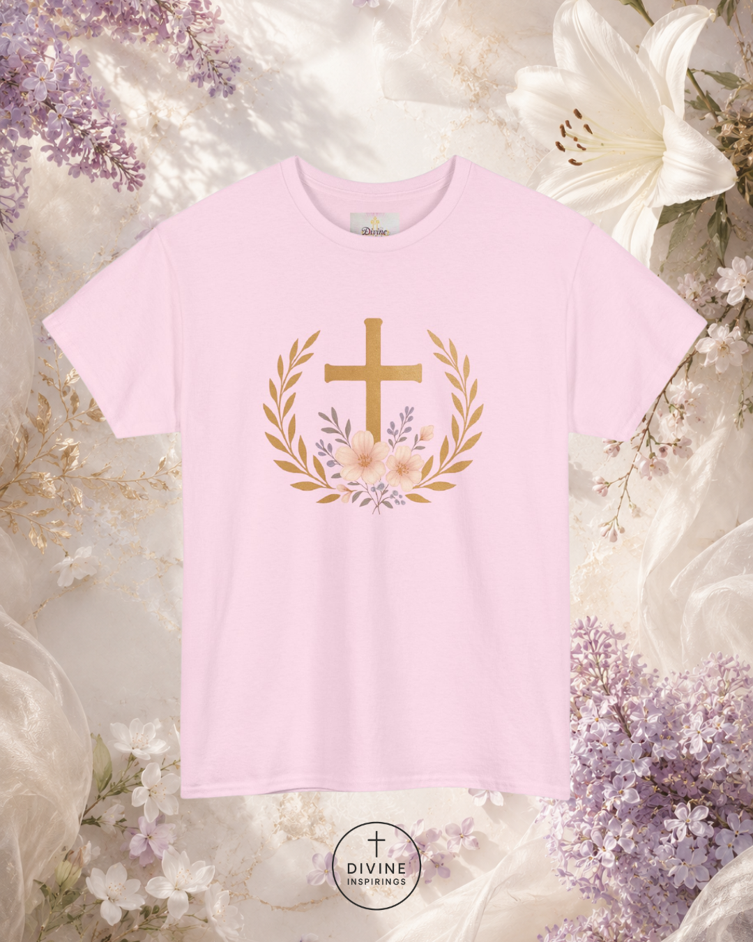 Pink t-shirt with a gold cross and floral wreath design on a floral background, featuring the brand 'Divine Emporium'.