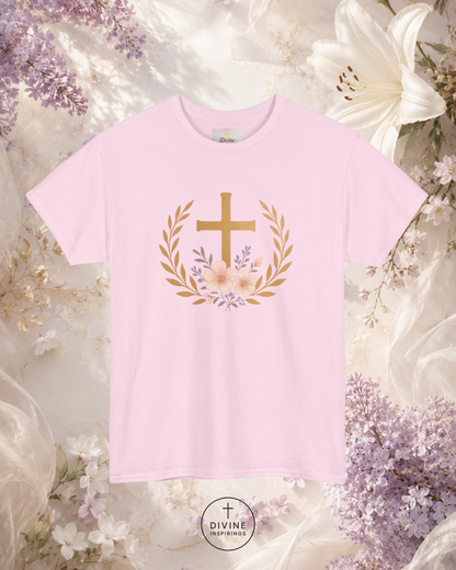 Pink t-shirt with a gold cross and floral wreath design on a floral background, featuring the brand 'Divine Emporium'.