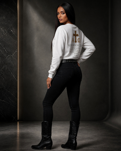 Person wearing a white sweatshirt with text and graphics, black pants, and black boots against a dark background