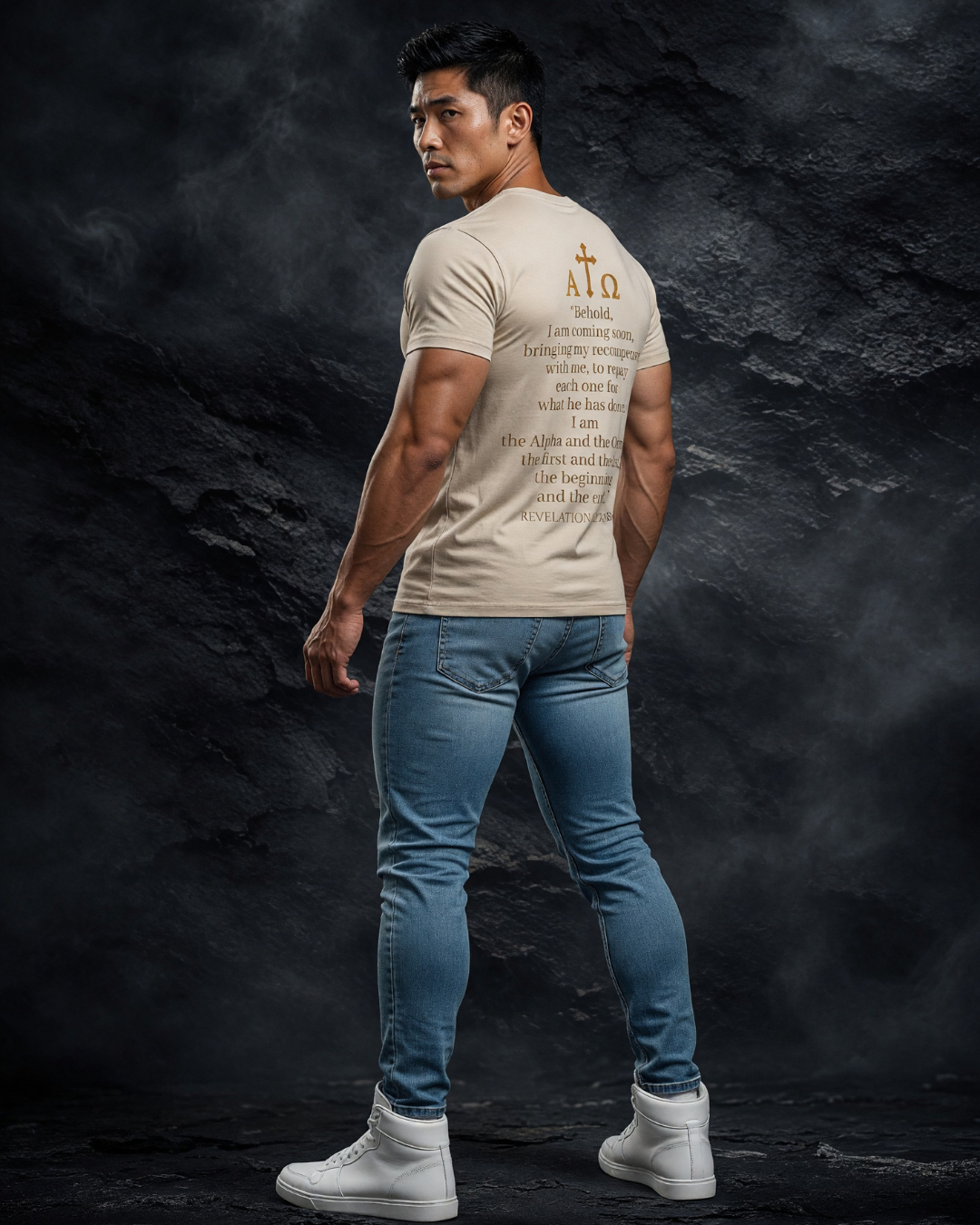 Man wearing a beige t-shirt with text and blue jeans on a dark textured background