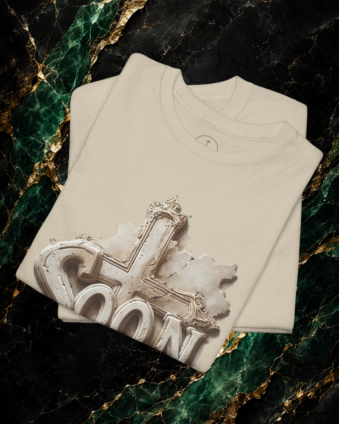 Folded beige t-shirt with decorative design on a marble surface