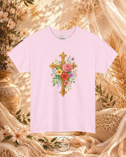 White t-shirt with floral cross design on a decorative background with flowers and fabric.