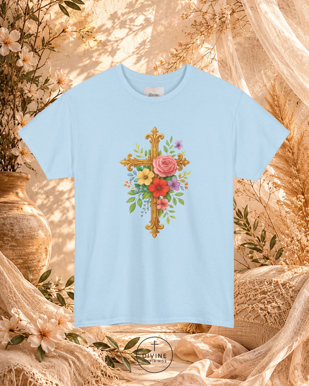 Light blue t-shirt with floral cross design on a decorative background