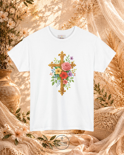 White t-shirt with floral cross design on a decorative background with flowers and fabric.