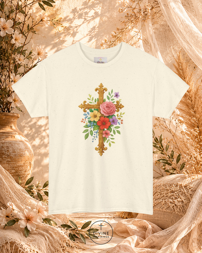 White t-shirt with floral cross design on a decorative background with flowers and fabric.