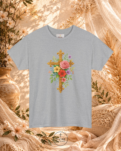 Gray t-shirt with floral cross design on a decorative background with flowers and fabric.