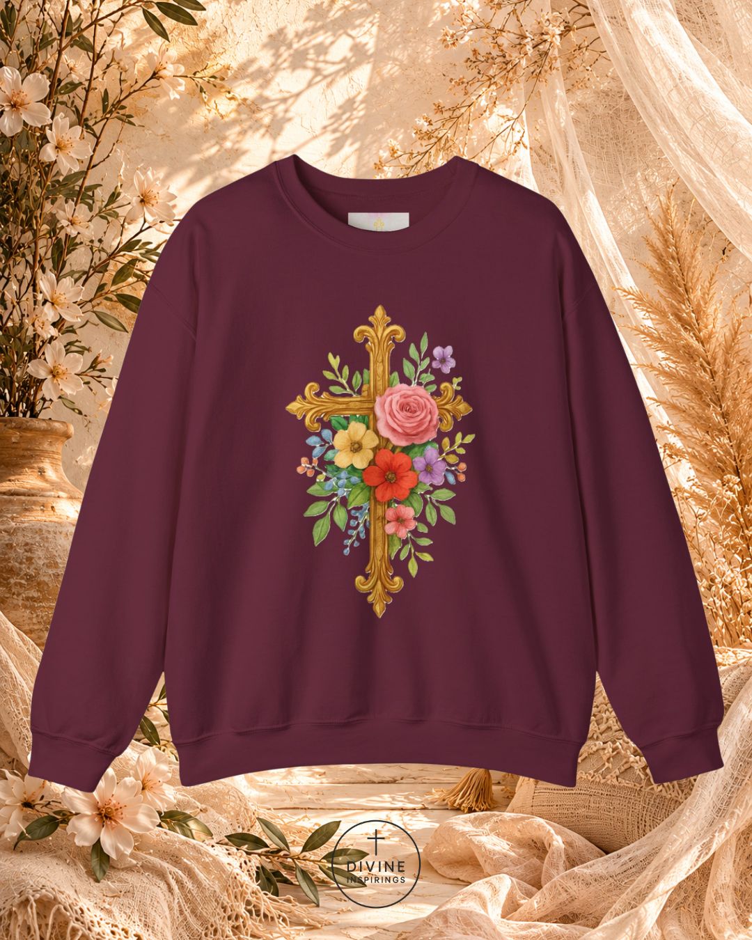 Maroon sweatshirt with floral cross design on a decorative background