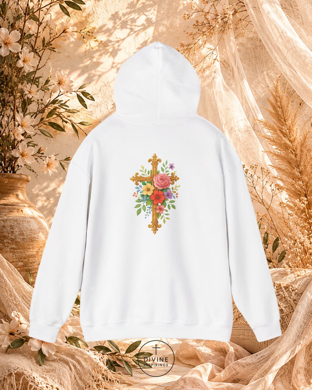 White hoodie with floral cross design against a natural background