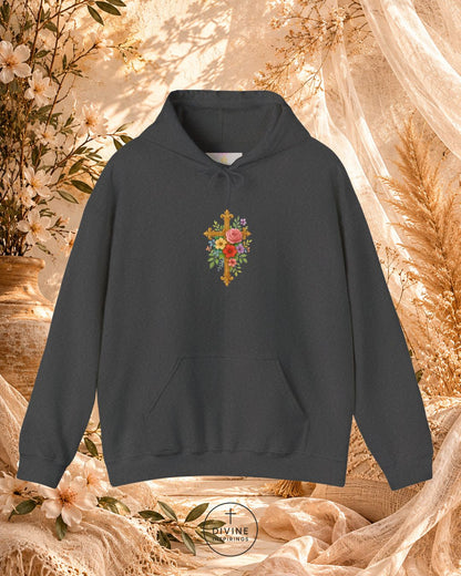 Black hoodie with floral cross design on a decorative background