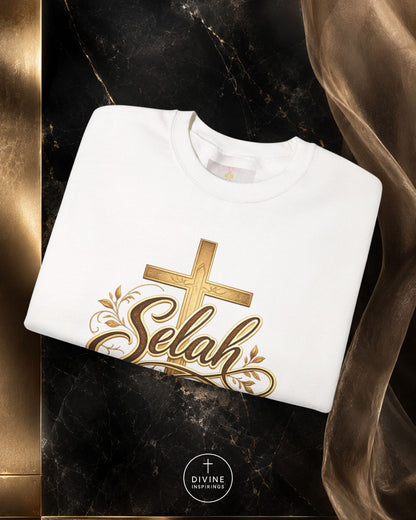 White sweatshirt with gold 'Selah' design on a dark marble surface