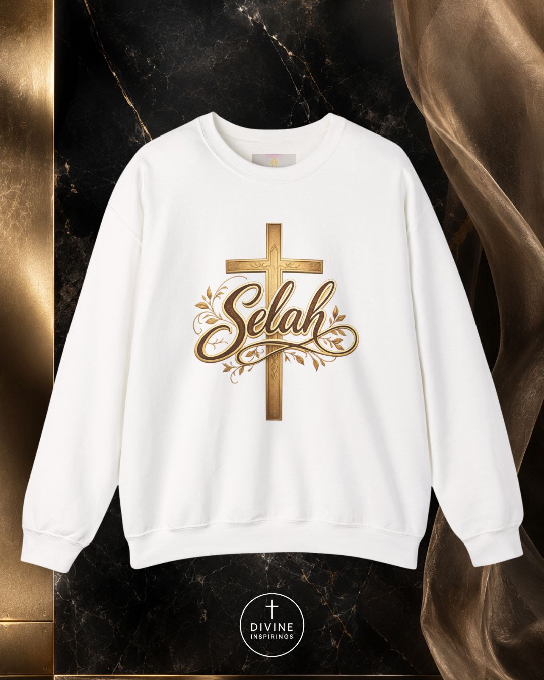 White sweatshirt with gold 'Selah' design on a dark marble background