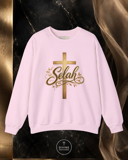 Beige sweatshirt with gold cross and 'Selah' text on a dark marble background