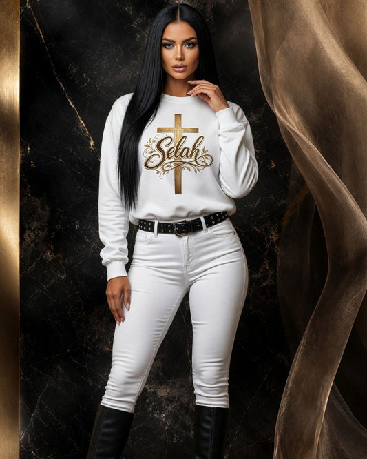 Woman wearing a white sweatshirt with 'Selah' design on a dark background