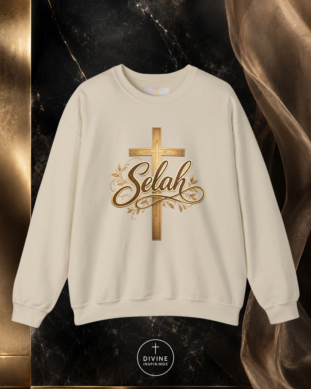 Beige sweatshirt with gold cross and 'Selah' text on a dark marble background