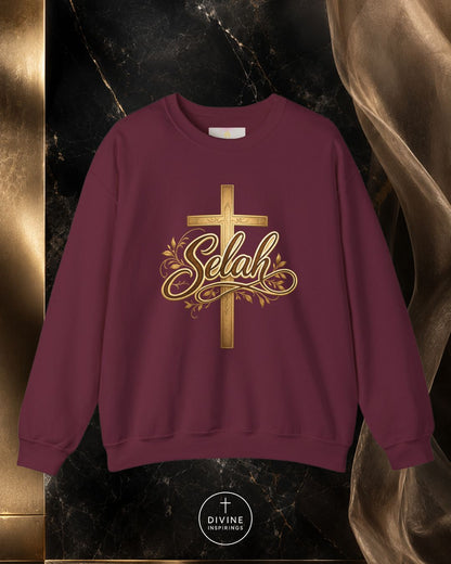 Maroon sweatshirt with gold cross and 'Selah' text on a dark marble background
