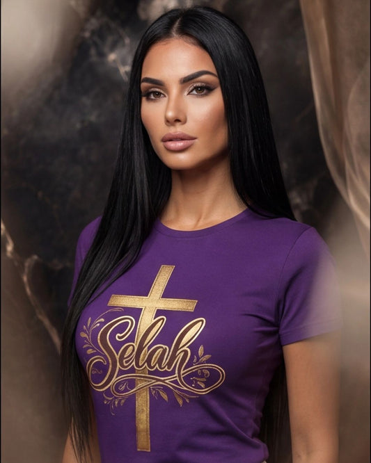 Woman wearing a purple t-shirt with a gold cross and 'Selah' design against a dark background