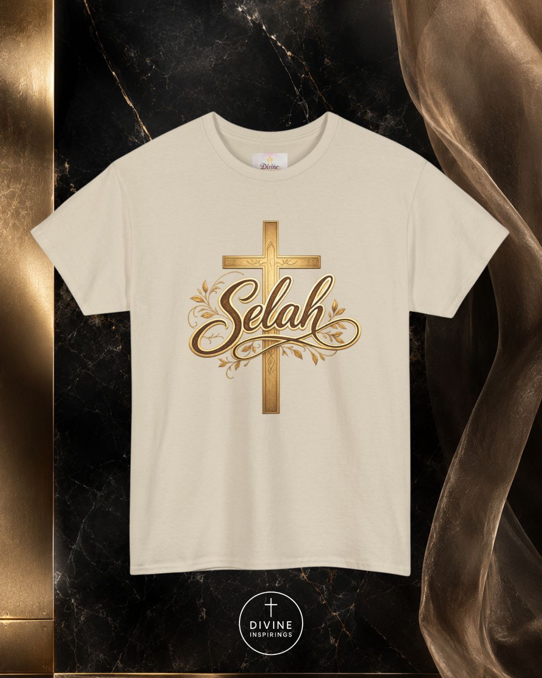 Beige t-shirt with gold cross and 'Selah' text on a dark marble background