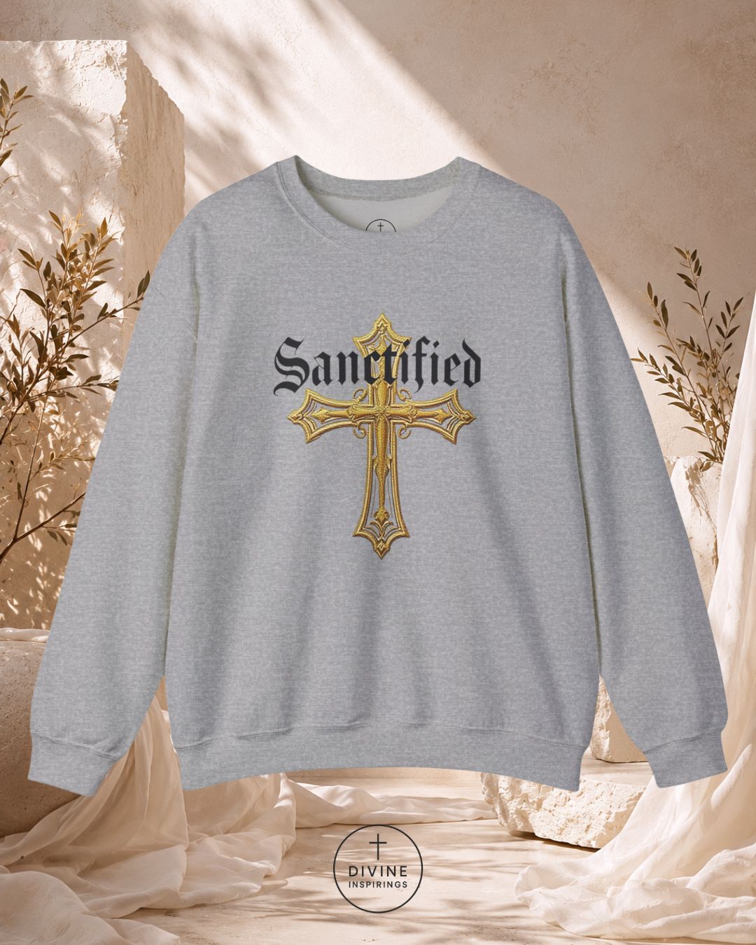 Gray sweatshirt with a gold cross and 'Sanctified' text on a neutral background