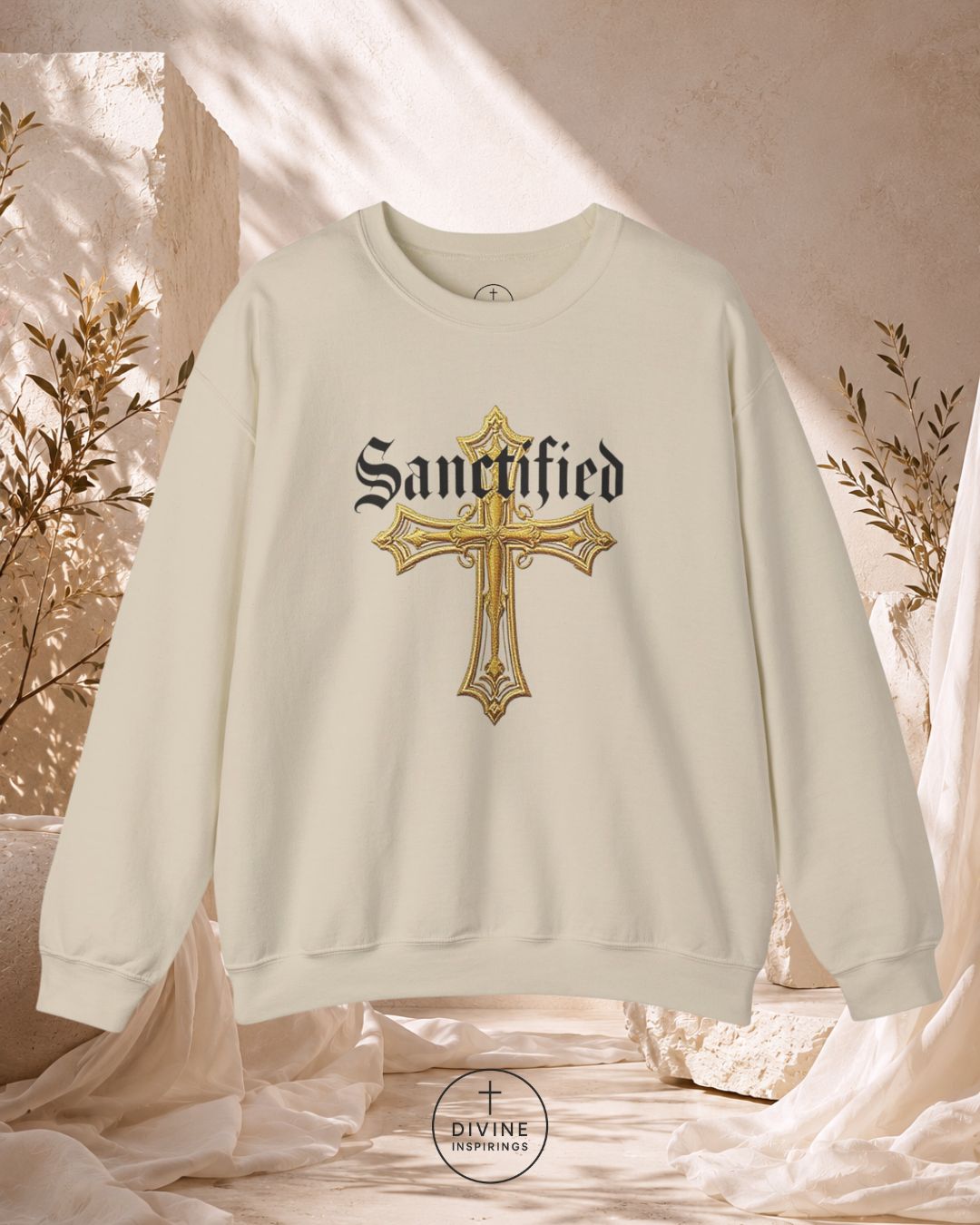 Beige sweatshirt with gold cross and 'Sanctified' text on a soft, neutral background