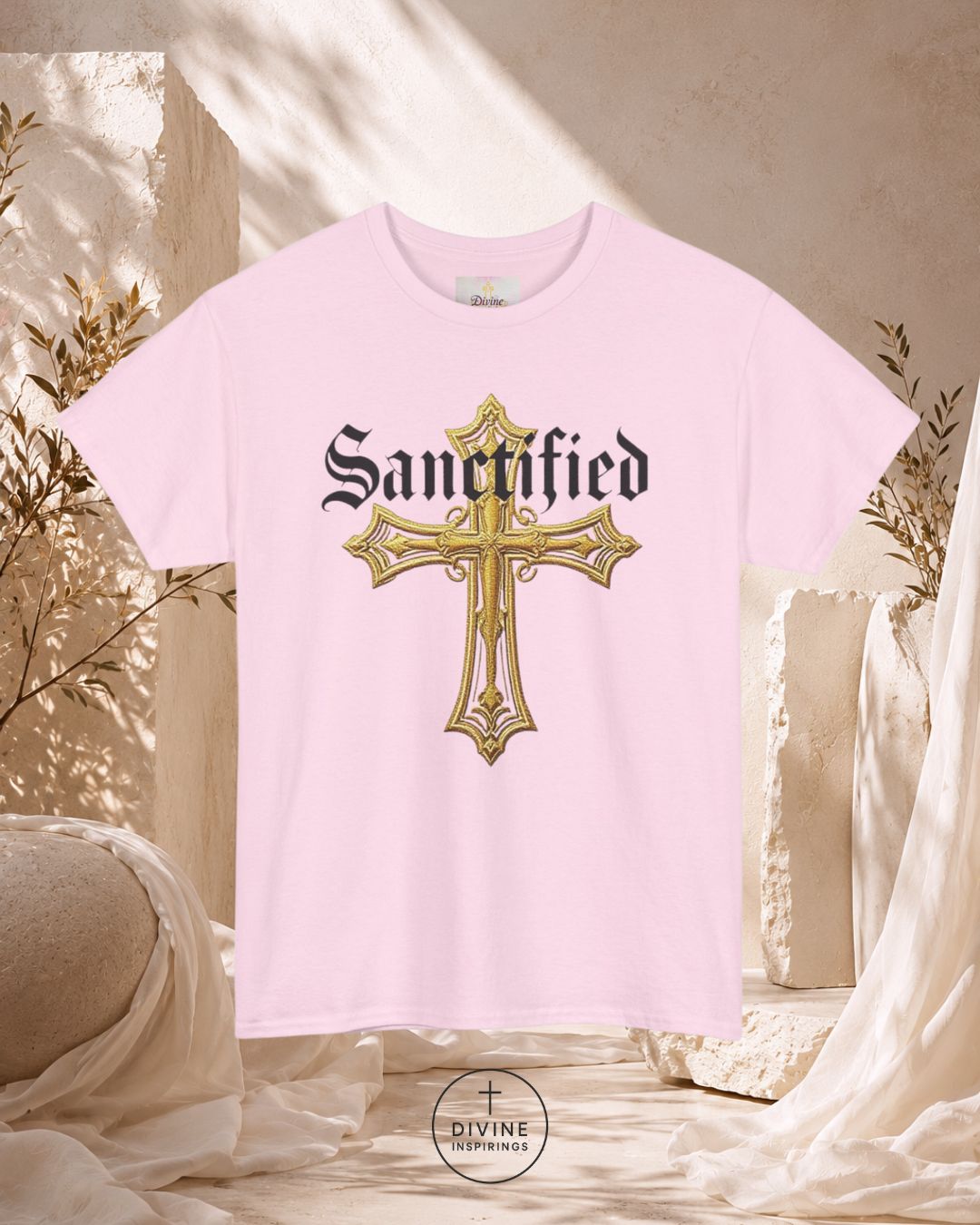 Pink t-shirt with a gold cross and 'Sanctified' text on a decorative background