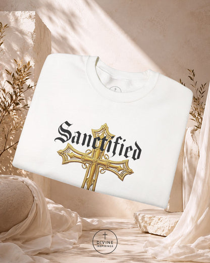 White sweatshirt with 'Sanctified' design featuring a gold cross on a neutral background