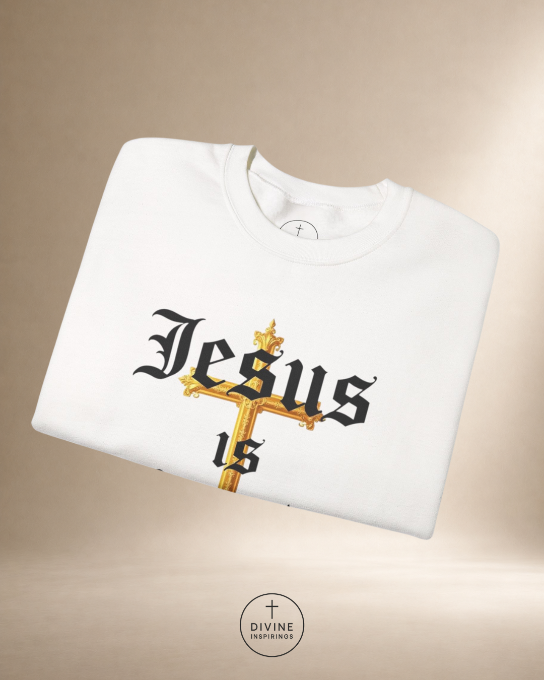 White t-shirt with 'Jesus is' design on a beige background