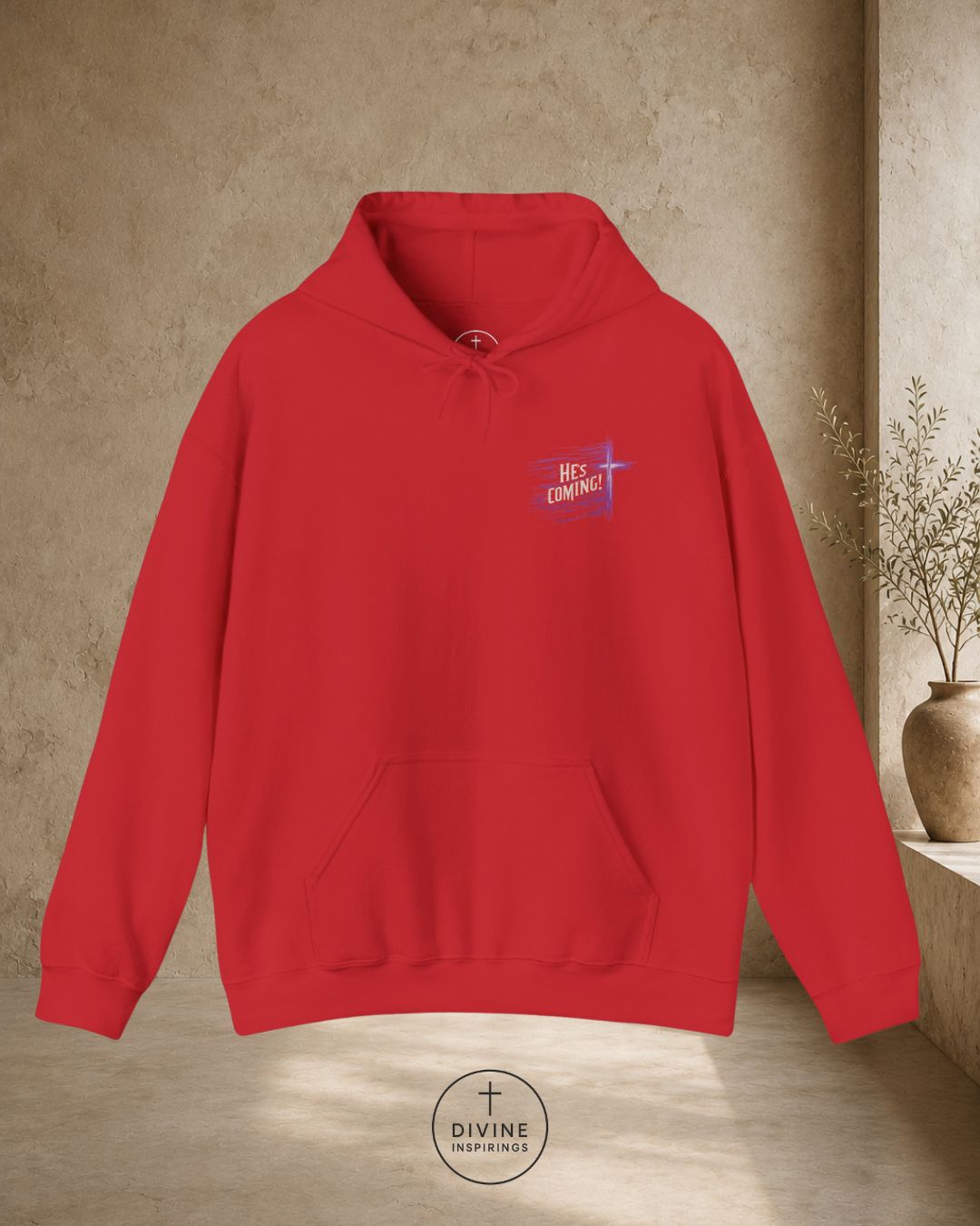 Red hoodie with a graphic design on the chest against a beige wall.