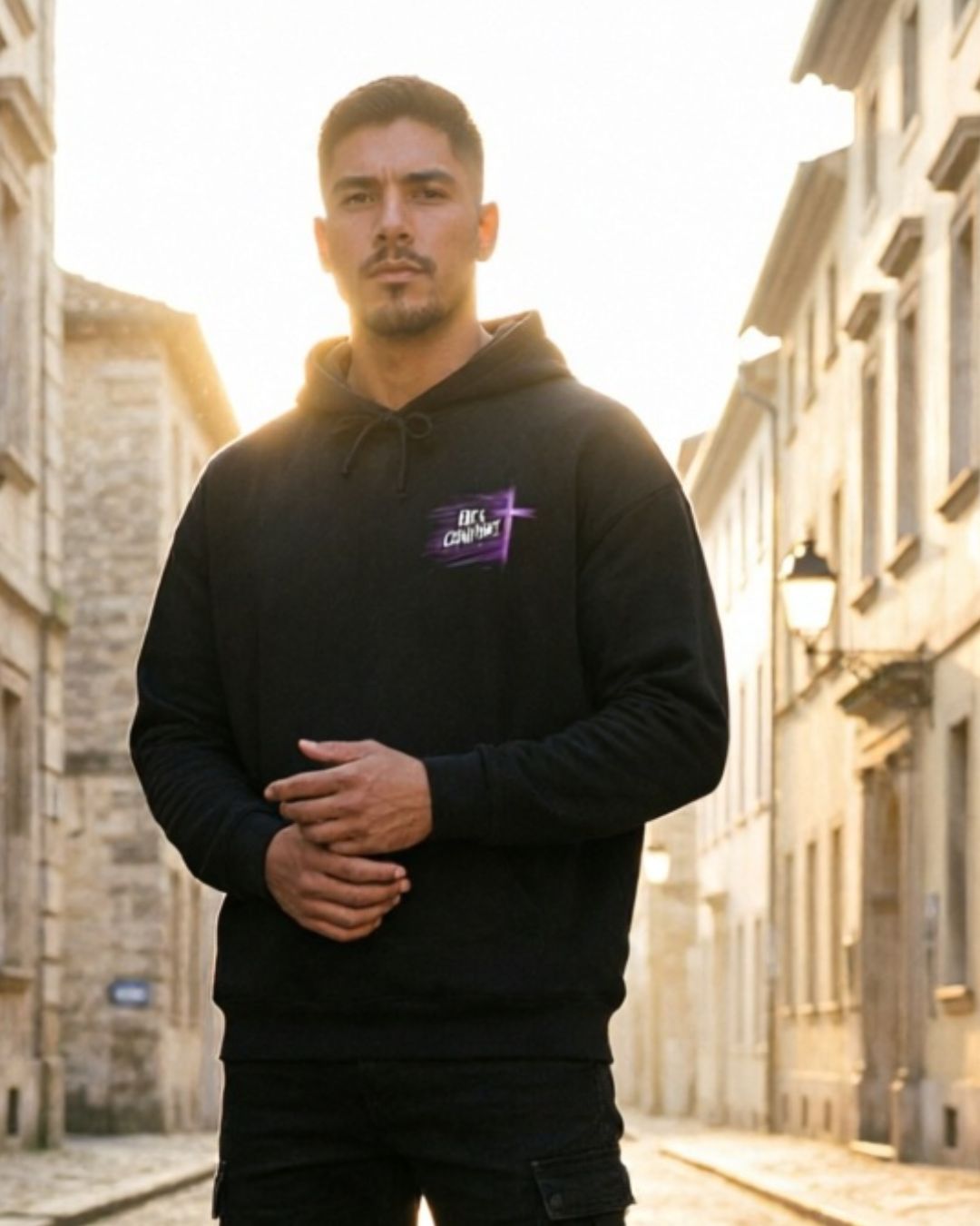 Man wearing a black hoodie with a logo on a street