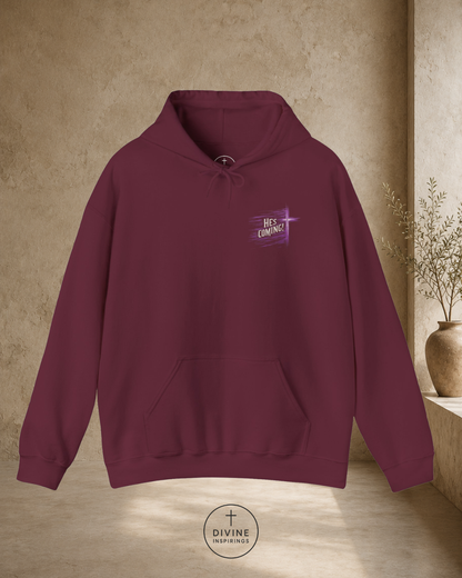 Maroon hoodie with a small logo on the chest against a beige wall.