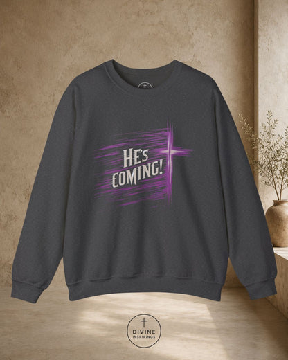 Dark gray sweatshirt with 'He's Coming!' text in purple on a beige background