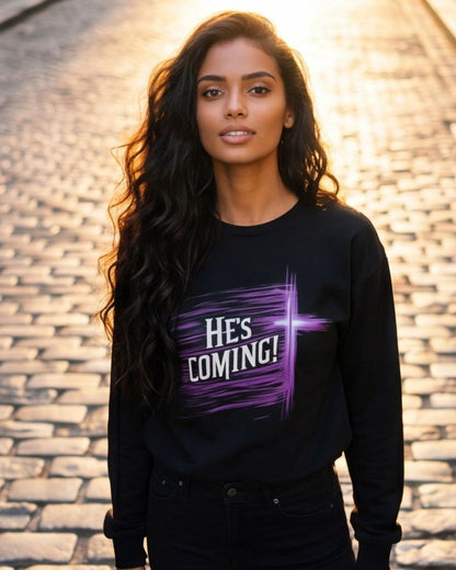 Woman wearing a black sweatshirt with 'HE'S COMING!' text on a stone pavement background