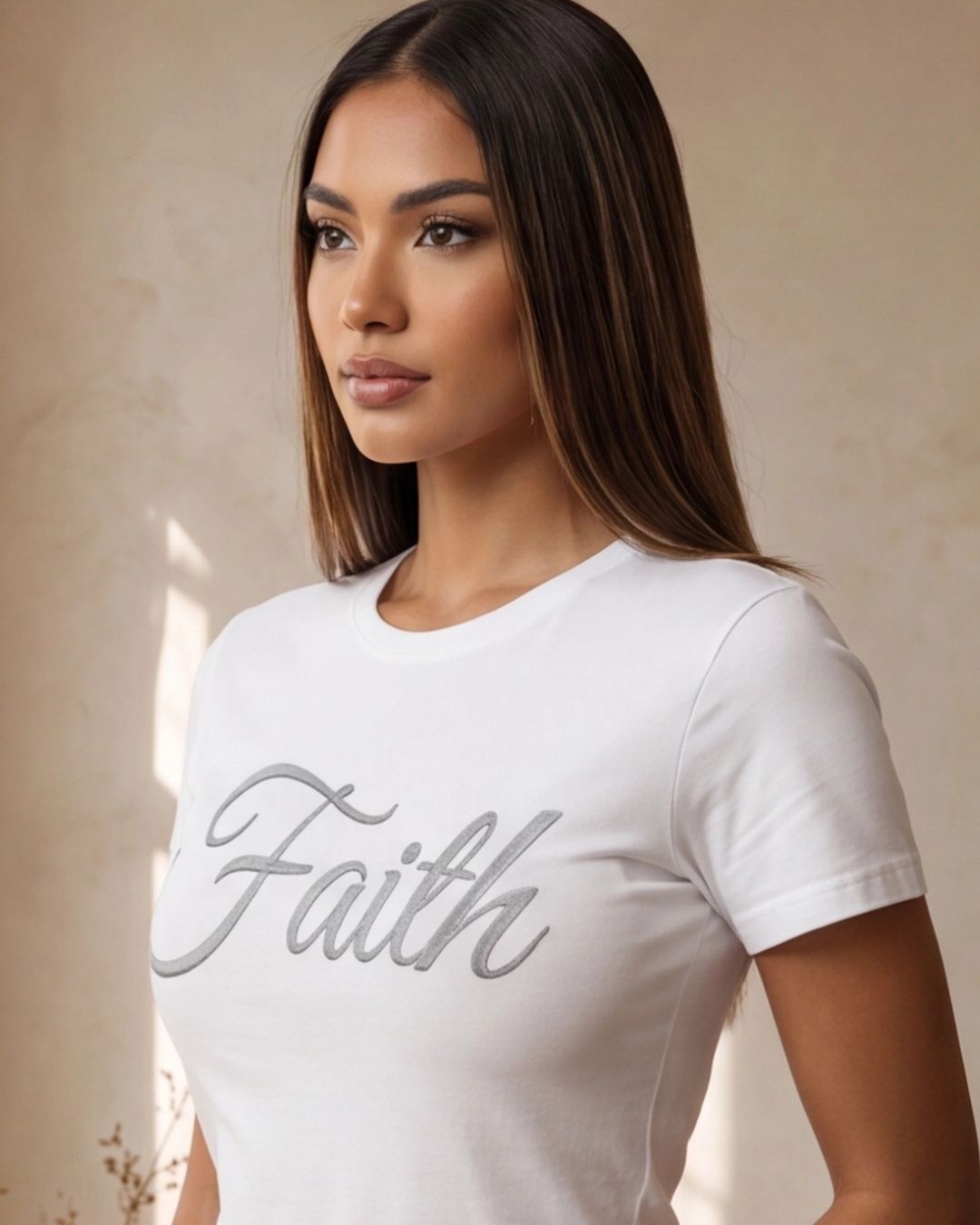 Woman wearing a white t-shirt with 'Faith' printed on it against a neutral background