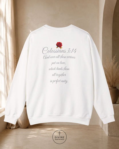 White sweatshirt with 'Colossians 3:14' text and a rose graphic on a neutral background