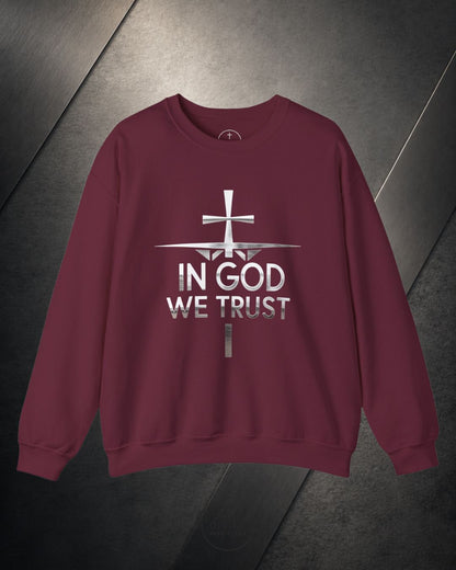 Maroon sweatshirt with 'In God We Trust' text and cross design on a metallic surface