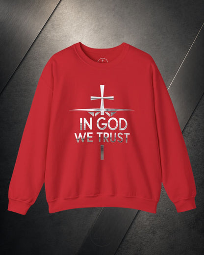 Red sweatshirt with 'In God We Trust' text and cross design on a dark surface