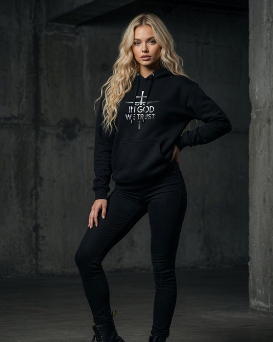 Woman wearing a black hoodie with text in a dark, industrial setting
