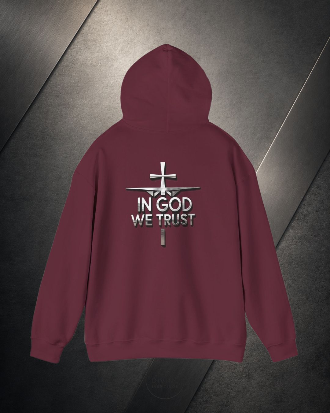 Maroon hoodie with 'In God We Trust' text and cross design on a metallic surface